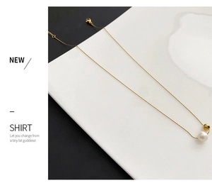 Vue détaillée d'un collier doré élégant orné d'une perle ronde et d'un pendentif en métal