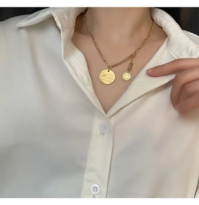 Titanium steel smiley face necklace with engraved round pendant worn on a white shirt