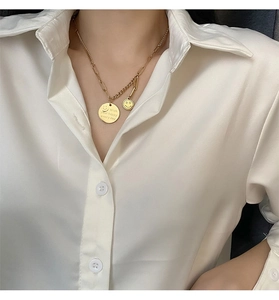 Close-up of golden smiley face necklace with Wish Your Happy Every Day engraving