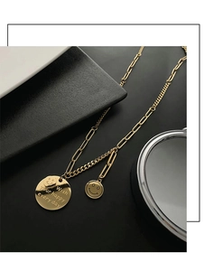 Macro detail of gold-plated smiley face pendants with engraved happy holiday message