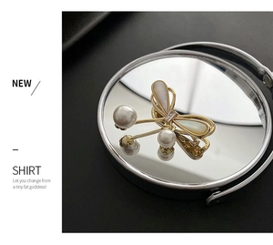 Macro detail of golden butterfly brooch featuring iridescent shells and white pearls