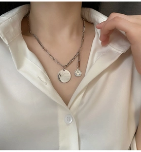 Close-up of smiley face pendant necklace with Wish Your Happy Every Day engraving