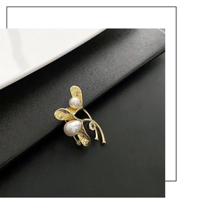 Macro detail of elegant golden branch brooch with white pearls and crystal inlay