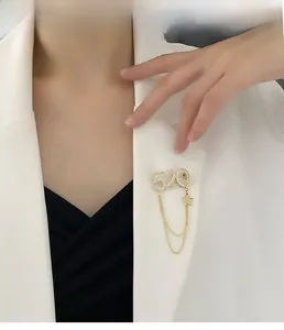 Détail d'une broche 520 de luxe avec chaîne et strass sur le revers d'un blazer