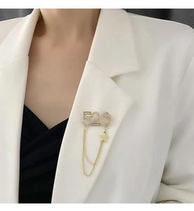 Détail d'une broche 520 dorée avec strass et pendentif étoile sur un revers de veste