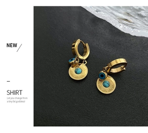 Detailed close-up of gold hoop earrings with evil eye and blue sun pendants