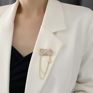 Broche dorée élégante chiffre 520 avec strass et doubles chaînes à pampilles