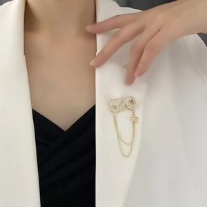 Broche chaîne 520 dorée élégante avec strass et pendentif étoile sur une veste blanche