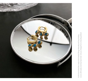 Vue macro de boucles d'oreilles anneaux œil bleu avec reflet sur un miroir