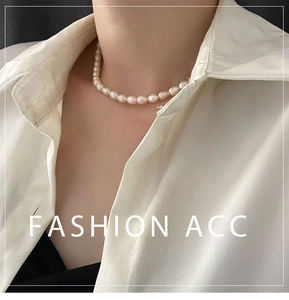 Close-up of baroque freshwater pearl necklace worn on collarbone with white shirt