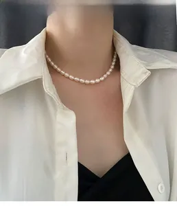 Elegant baroque freshwater pearl necklace worn by a model on a white shirt