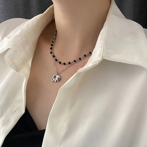 Double-layered titanium steel necklace with elephant pendant on model's neck