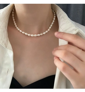 Close-up of rice-shaped baroque freshwater pearl necklace worn by a model on the neck