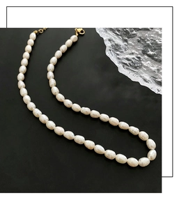 Close-up of baroque freshwater pearl necklace with golden ring clasp on black background