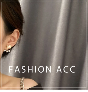 Close-up of bow knot stud earrings with three pearls on a dark velvet background