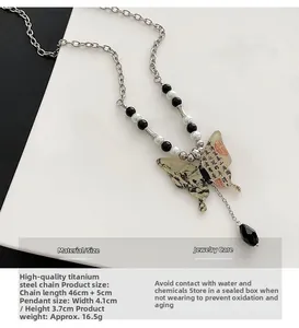 Détail macro du pendentif papillon avec calligraphie sur collier en acier poli