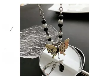Gros plan du pendentif papillon avec art chinois et perles noires sur collier chic