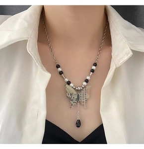 Détail du pendentif papillon avec peinture de paysage traditionnel et perles