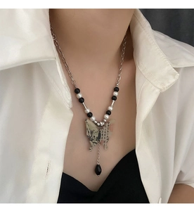 Détail du collier pendentif papillon style encre de Chine avec perles noires et blanches