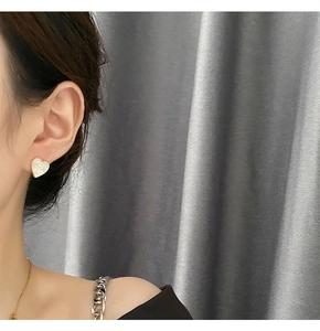 Details asymmetrischer Herzohrstecker mit Kristallen und weißem Inlay am Modell