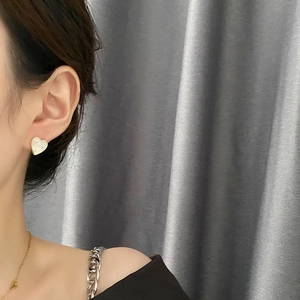 Minimalistische Herz-Ohrstecker mit Kristallen und weißem Emaille am Model getragen
