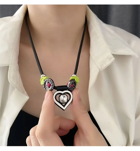 Détail du collier pendentif cœur avec cordon noir et pierre centrale carrée brillante