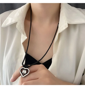 Détail du pendentif cœur argenté avec pierre brillante sur une chaîne à billes noire