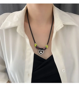 Détail du collier pendentif cœur avec cristal transparent sur un cordon noir tressé