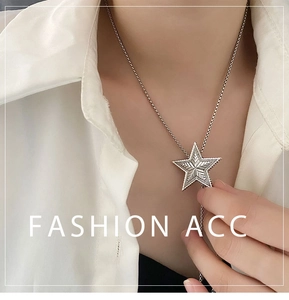 Close-up of vintage silver star pendant with radial engraving on a necklace