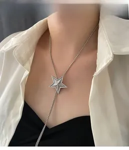 Detail of silver star pendant with geometric texture on a delicate bead chain