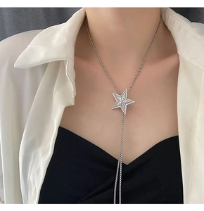 Close-up of a silver vintage star pendant necklace with fringe tassel chain details