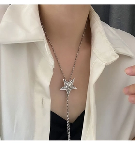 Detail of silver star Y-necklace on model showing the vintage relief texture and drape