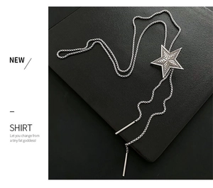 Detail of star pendant necklace with star engraving and metal chain on black background