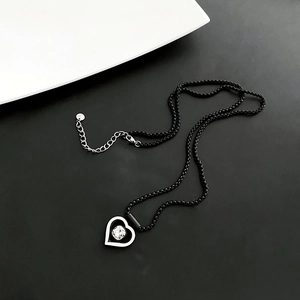 Collier cœur minimaliste avec chaîne à billes noires et pendentif cristal sur noir