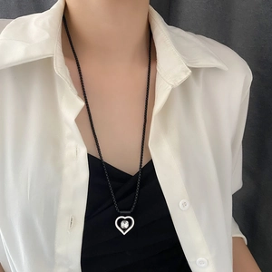 Collier avec pendentif cœur et pierre précieuse sur cordon noir porté par un mannequin