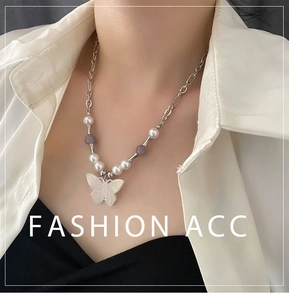 Detail of butterfly pendant necklace with natural stone beads and metal chain on model