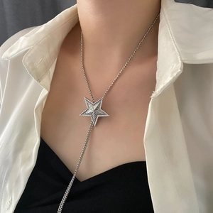 Vintage silver star pendant necklace with adjustable pull chain on white shirt model