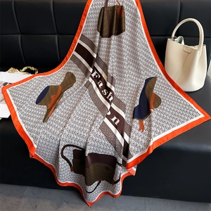 Detailed view of elegant silk scarf with fashion illustrations on luxury sofa