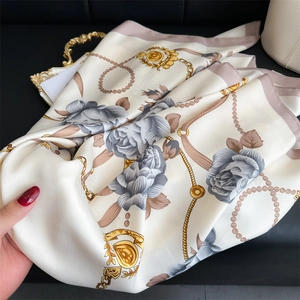 Carré de soie aux motifs de camélias, chaînes dorées et perles sur fond crème élégant