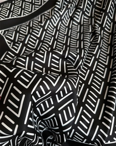 Detalle de un pañuelo de seda de lujo con patrones lineales geométricos en blanco y negro