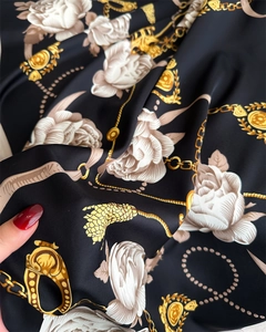Détail d'un foulard en soie avec motif floral camélia et imprimé chaîne baroque doré