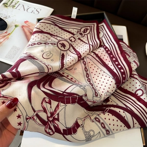 Detail of silk-feel scarf featuring equestrian prints and smooth twill texture finish