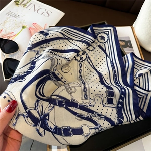 Detail of blue and white silk scarf with equestrian horse buckle and strap prints