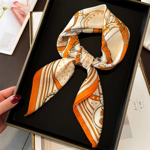 Close-up of equestrian print silk scarf with chain patterns in a black gift box