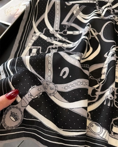 Detailed view of the equestrian chain print on lightweight black and white silk scarf