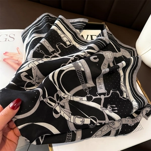 Detail of silk-like scarf with equestrian chain print and smooth satin texture