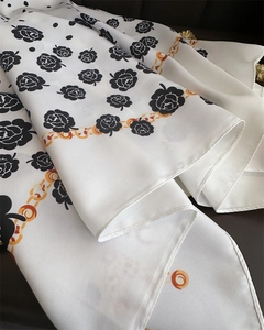 Detail of silk scarf showing black rose floral pattern and twill fabric texture