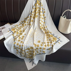 Detailed pattern of white silk scarf with yellow floral and polka dot chain design