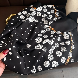 Detail of silk scarf with camellia and chain pattern showing soft texture and drapes