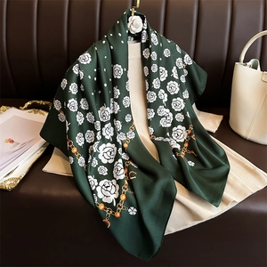Detail of silk scarf showing camellia floral prints, golden chains and polka dot patterns